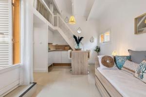 a living room with a couch and a staircase at Appartement Pinède in Cap d'Agde