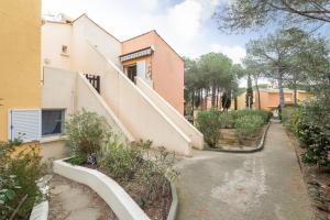 a house with a staircase in a yard at Appartement Pinède in Cap d'Agde