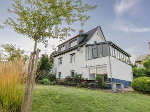 a white house with black windows and a yard at Dorfhaus1953 in Eslohe