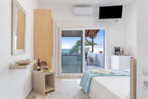a bedroom with a bed and a view of the ocean at Niki's Studios Kalymnos in Kalymnos