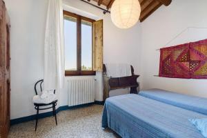 a bedroom with two beds and a window at La Ripa - Appartamento I Nidi in San Gimignano +19 photos