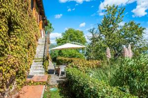 a stairway leading up to a house with an umbrella at La Ripa - Appartamento I Nidi in San Gimignano