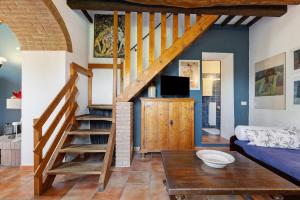 a living room with a staircase and a couch at La Ripa - Appartamento I Nidi in San Gimignano