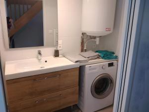 a bathroom with a sink and a washing machine at Gîte Des Caves in Civray-de-Touraine