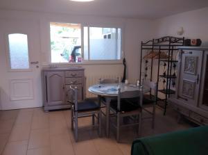 a kitchen with a table and chairs and a window at Gîte Des Caves in Civray-de-Touraine +3 photos