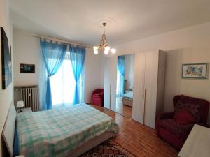 a bedroom with a bed and a chair and a window at Casa Delle Gemme in Valenza