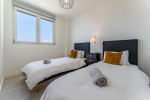 two beds in a white room with a window at Luxury Penthouse with Rooftop in Fuengirola +20 photos