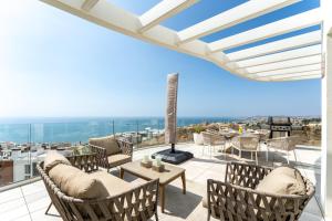 a patio with furniture and a view of the ocean at Luxury Penthouse with Rooftop in Fuengirola