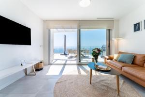 a living room with a couch and a tv at Luxury Penthouse with Rooftop in Fuengirola