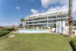 a large white building with a swimming pool and a resort at Luxury Penthouse with Rooftop in Fuengirola