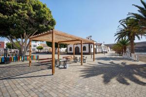a pavilion with benches and trees on a street at La Lajita Beach Estudio in Lajita