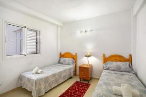 a bedroom with two beds and a window at Rach Agaete in Agaete +21 photos