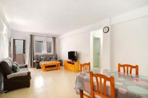 a living room with a dining table and a tv at Rach Agaete in Agaete