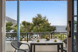 a table and chairs on a balcony with a view of the ocean at Niki's Studios Kalymnos in Kalymnos