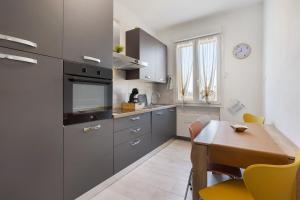 a kitchen with a wooden table and a dining room at Suite Ponte Vecchio in Pavia