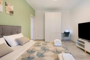 a bedroom with a large bed and a flat screen tv at Suite Ponte Vecchio in Pavia