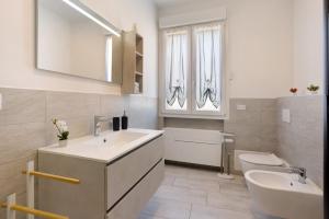 a bathroom with two sinks and a toilet at Suite Ponte Vecchio in Pavia +13 photos