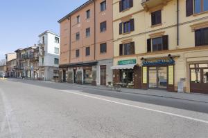 an empty city street with buildings and a bike on the street at Suite Ponte Vecchio in Pavia