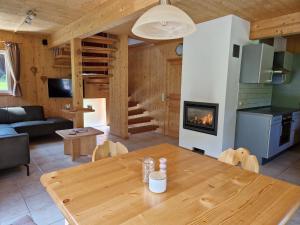a living room with a wooden table and a fireplace at Chalet Martina in Stadl an der Mur