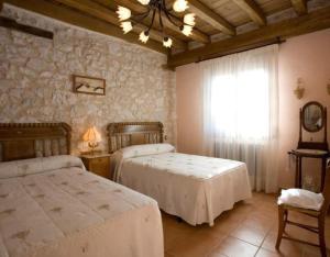 ein Schlafzimmer mit zwei Betten und einem Fenster in der Unterkunft Las Espigas in Canalejas de Peñafiel