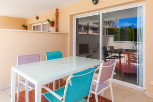 a dining room with a white table and chairs at Apartamento Espiga in Cala Bona