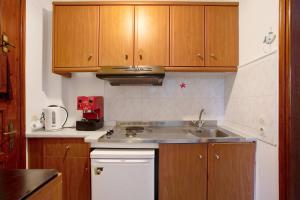 a kitchen with wooden cabinets and a sink at Areti Orfeas Apartment 3 in Vasilikos +21 photos