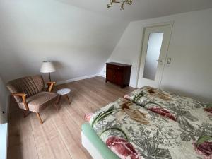 a bedroom with a bed and a chair at Kleines Haus am Feld in Rehna