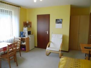 a living room with a table and a chair and a kitchen at Apartment Neuenrade in Neuenrade