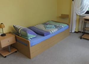 a small bed in a room with a night stand at Apartment Neuenrade in Neuenrade