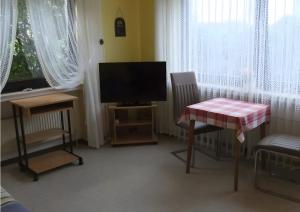 a living room with a television and a table and a table and chairs at Apartment Neuenrade in Neuenrade