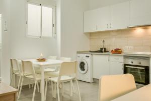 a white kitchen with a white table and chairs at 1a Van Halen in Vecindario +12 photos
