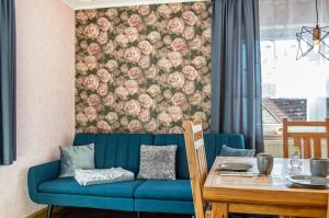 a living room with a blue couch and a table at Fewo Kleinert in Billingsbach