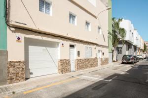 a white building with a garage on the side of a street at 1a Van Halen in Vecindario