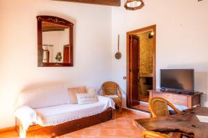 a living room with a white couch and a tv at Ses Solls in Petra