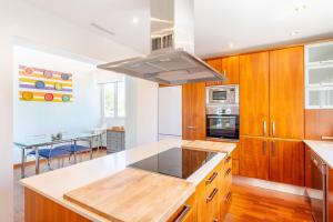 a kitchen with wooden cabinets and a stove top oven at Casa La Siesta in Cala d´Or