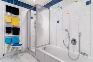 a bathroom with a shower and a tub and a stool at Ferienwohnung Rheinvorland in Linx +20 photos