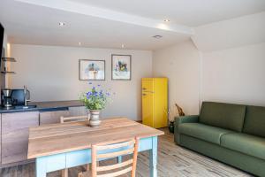 a living room with a table and a green couch at Aumia Apartment Opal in Völs am Schlern +16 photos