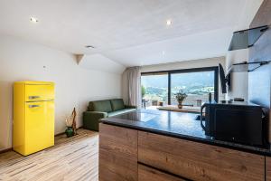 a kitchen with a counter with a tv and a couch at Aumia Apartment Opal in Völs am Schlern