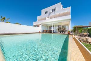 a villa with a swimming pool in front of a house at Casa La Siesta in Cala d´Or