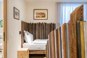 a room with a bed and a bunch of surfboards at Aumia Apartment Opal in Völs am Schlern
