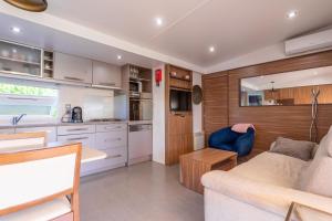 a caravan kitchen and living room with a couch and a table at Le Mediterranéen in Fréjus