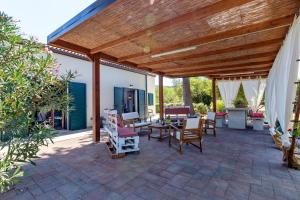 a patio with chairs and a wooden pergola at La Casa di Valverde in Alghero