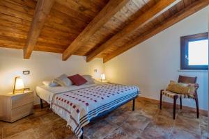 a bedroom with a bed and a wooden ceiling at La Casa di Valverde in Alghero