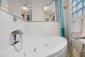 a white bathroom with a tub and a sink at Casa Armando in Laglio +17 photos