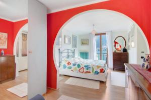 a bedroom with a bed and a red wall at Casa Armando in Laglio
