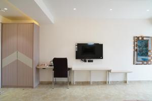 a room with a desk and a tv on a wall at Ascent Eco Resorts & Conventions in Rājānagaram