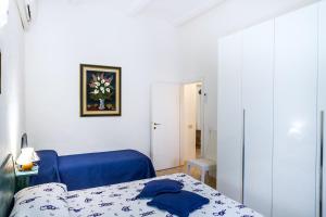 a bedroom with a bed and a blue chair at Palmiro in Castiglione della Pescaia