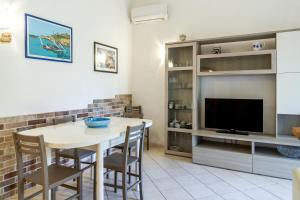 a living room with a table and a tv at Palmiro in Castiglione della Pescaia