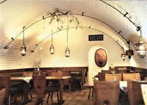 a dining room with tables and chairs and lights at Schmiede Burkheim in Vogtsburg