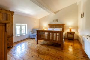 a bedroom with a bed and a chair and a window at Maison Vigneronne-piscine et vignes in Trèbes +15 photos